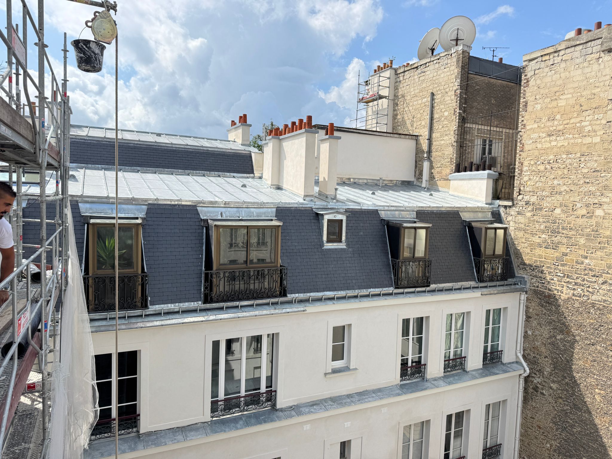 Row of red roofs with chimneys on top. Fog over tiled roofs in old town